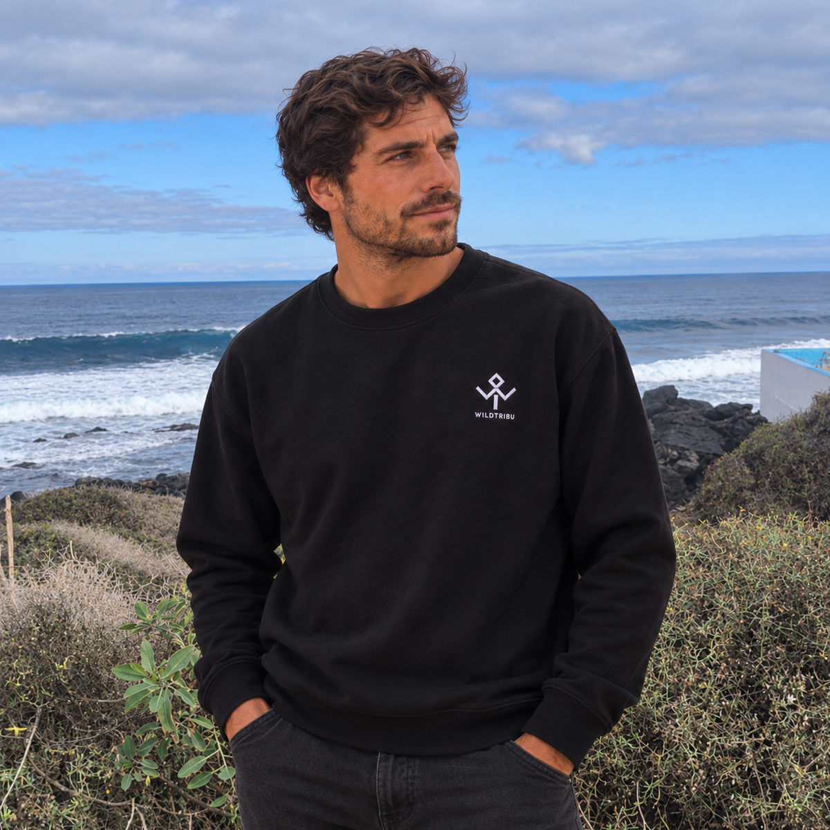 Sudadera negra Ocean and Fire, detalle frontal del logo bordado junto al mar