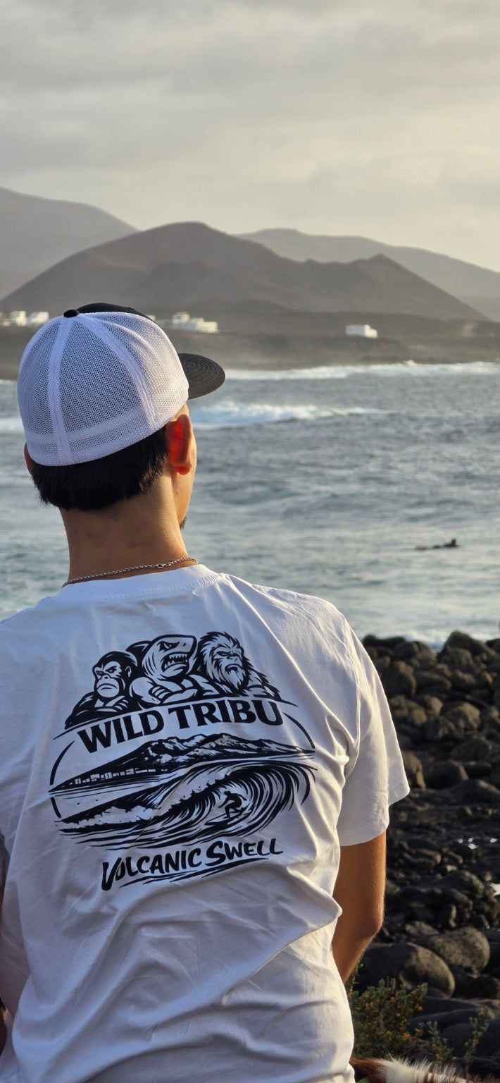 Detalle de la gráfica Volcanic Swell en la camiseta blanca junto al mar